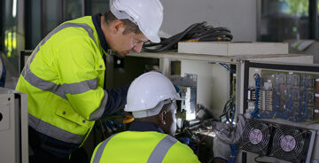 Two electricians assessing equipment